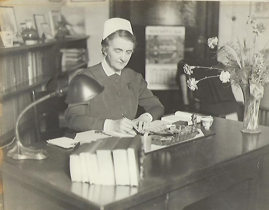 superintendent holt at her desk with fresh cut flowers