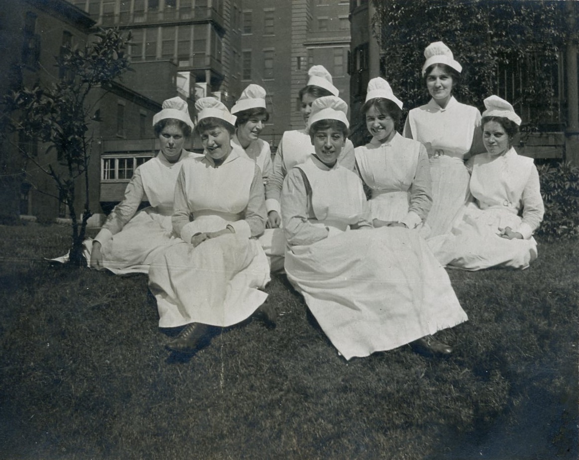 nursing students relaxing on lawn outside their residence