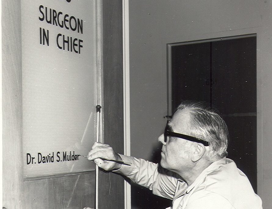 Gregory Danko paints sign on Dr. Mulder's office door